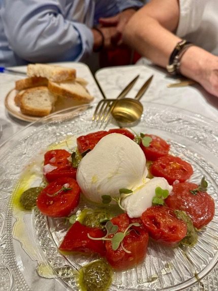 Ensalada Capri: tomate y burrata sobre plato de cristal